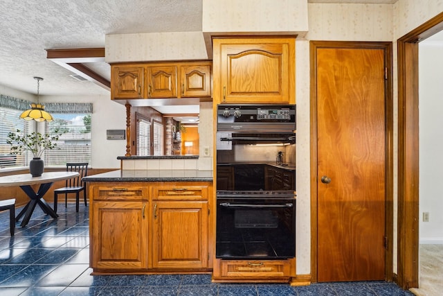 kitchen featuring a textured ceiling, double oven, and decorative light fixtures