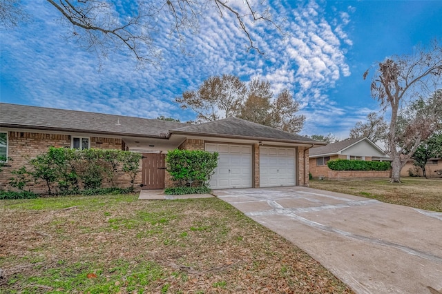 single story home with a garage and a front lawn