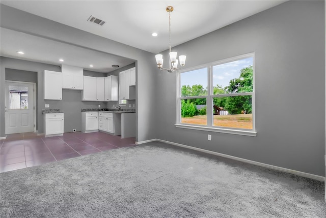 kitchen featuring white cabinetry, a chandelier, dark carpet, and pendant lighting