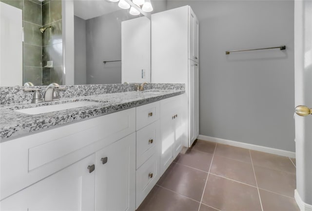 bathroom with tile patterned flooring, vanity, and walk in shower