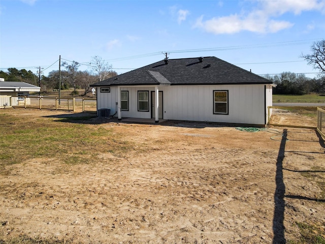 rear view of property featuring central AC and a lawn