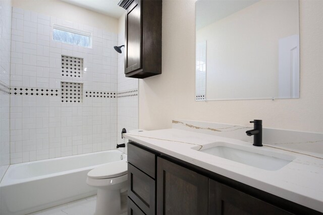 full bathroom featuring tiled shower / bath combo, vanity, and toilet