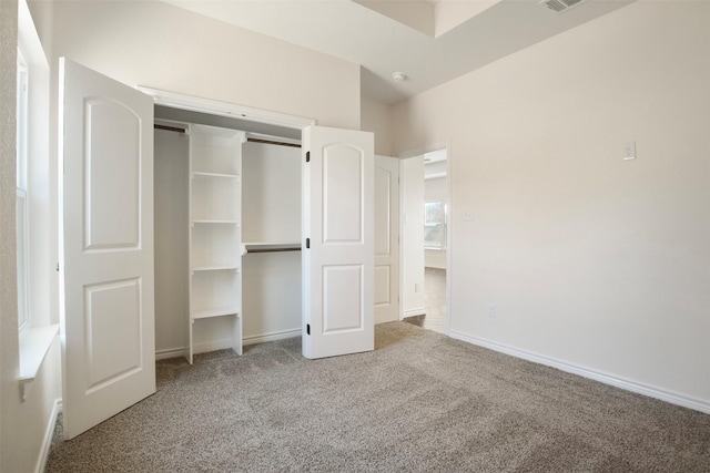 unfurnished bedroom with light carpet and a closet