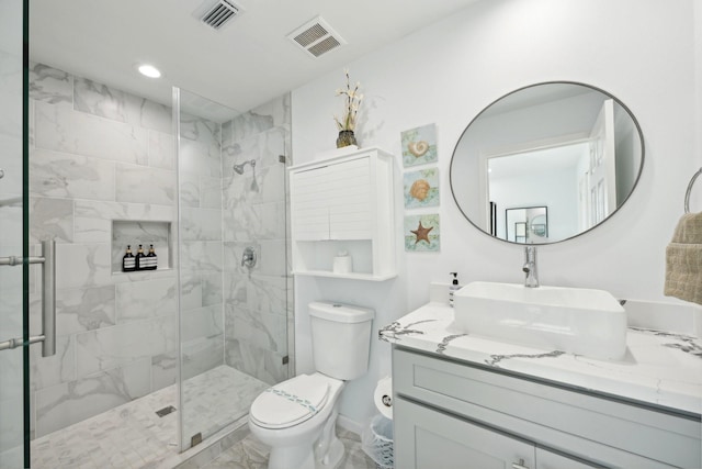 bathroom with vanity, a shower with shower door, and toilet