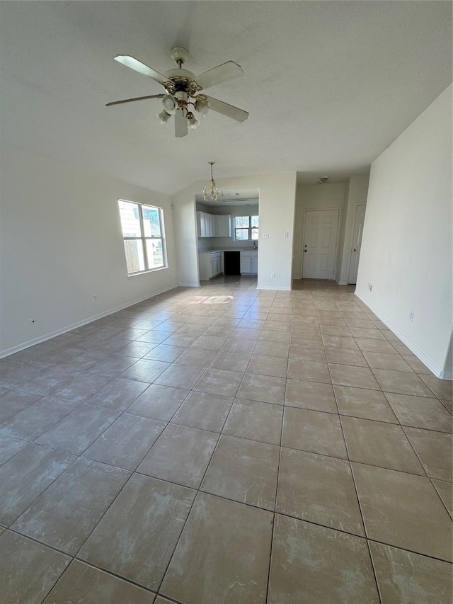 unfurnished living room with light tile patterned floors and ceiling fan with notable chandelier