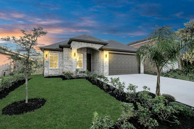 view of front facade featuring a garage and a yard