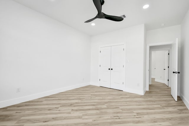 unfurnished bedroom with light hardwood / wood-style floors, ceiling fan, and a closet