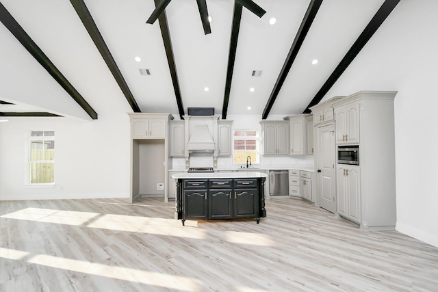 kitchen featuring a kitchen island, beamed ceiling, custom exhaust hood, ceiling fan, and stainless steel appliances