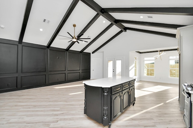 kitchen featuring french doors, a kitchen island, ceiling fan, beam ceiling, and light hardwood / wood-style floors