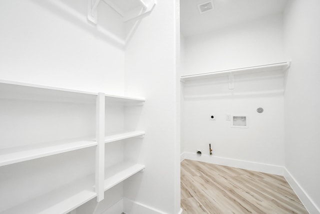 laundry room with gas dryer hookup, washer hookup, light hardwood / wood-style flooring, and hookup for an electric dryer