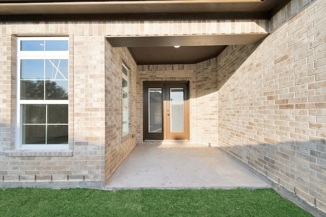 property entrance featuring a patio and french doors