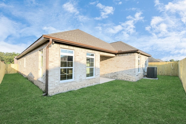 rear view of house with a yard and central air condition unit