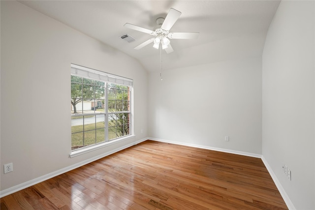 unfurnished room featuring lofted ceiling, ceiling fan, wood finished floors, visible vents, and baseboards