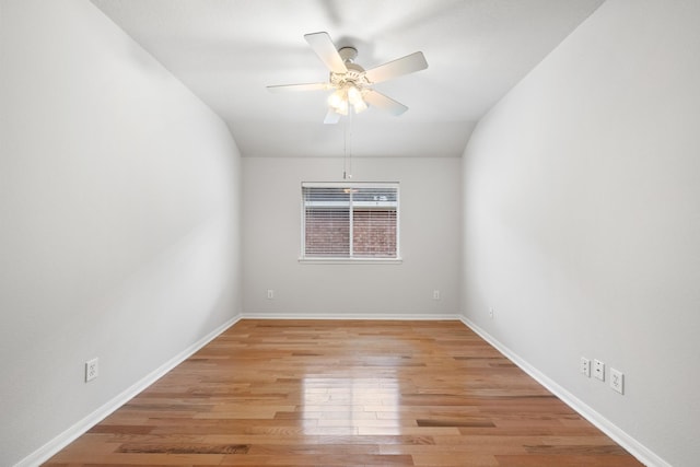 spare room featuring light wood-style floors, ceiling fan, and baseboards