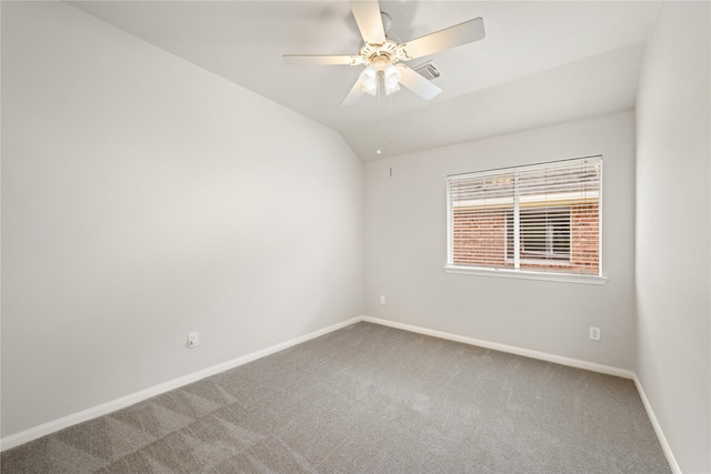 carpeted spare room featuring vaulted ceiling, ceiling fan, and baseboards