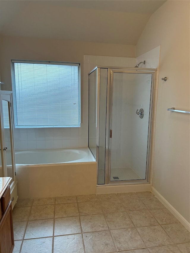 bathroom featuring lofted ceiling, a garden tub, a stall shower, and vanity