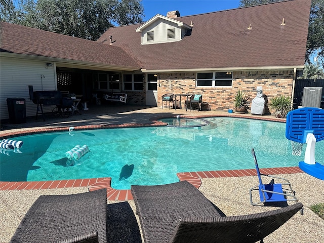 view of swimming pool with an in ground hot tub and a patio area