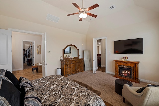 bedroom featuring ceiling fan, a walk in closet, vaulted ceiling, and a closet