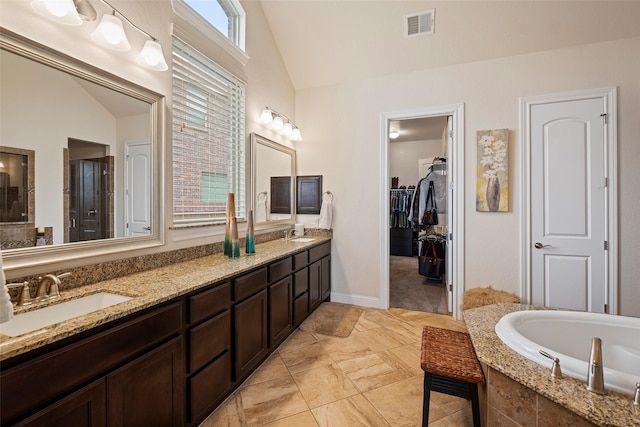 bathroom featuring vanity, vaulted ceiling, and shower with separate bathtub