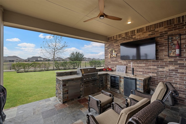 view of patio / terrace featuring exterior kitchen, area for grilling, beverage cooler, and ceiling fan