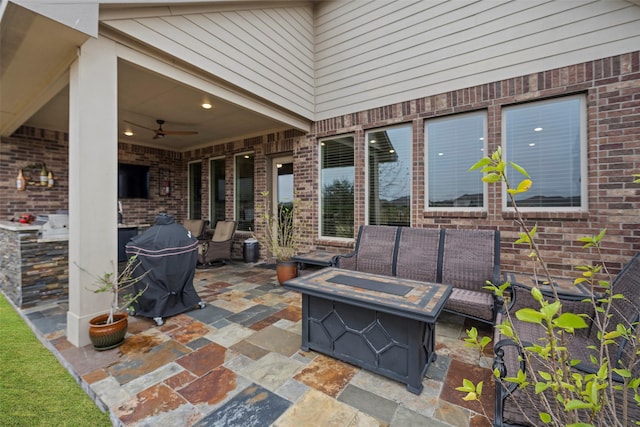 view of patio with an outdoor living space with a fire pit