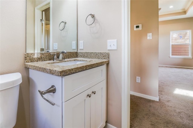 bathroom featuring toilet, vanity, and baseboards