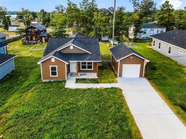 view of front facade featuring driveway, a front yard, and roof with shingles