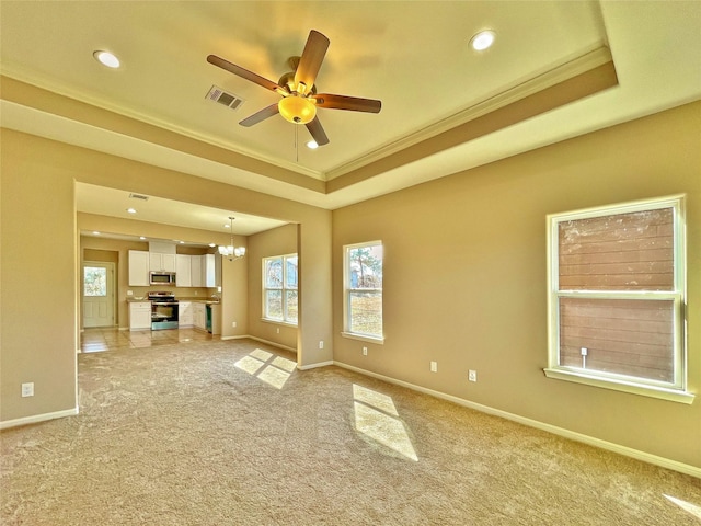 unfurnished living room featuring light colored carpet, a raised ceiling, visible vents, and baseboards