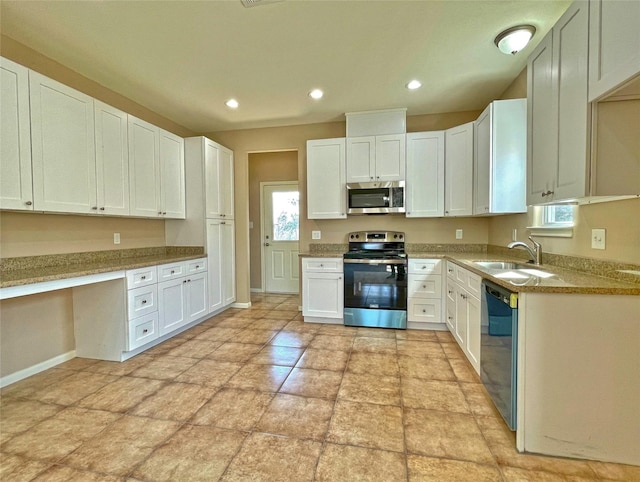 kitchen with sink, built in desk, white cabinets, and appliances with stainless steel finishes