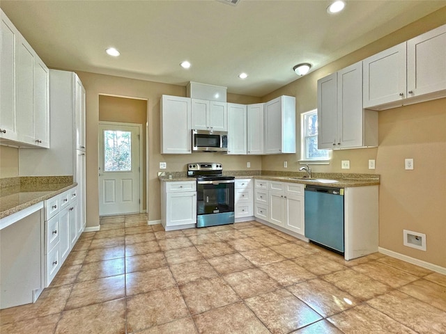 kitchen with light stone counters, stainless steel appliances, visible vents, a healthy amount of sunlight, and white cabinetry