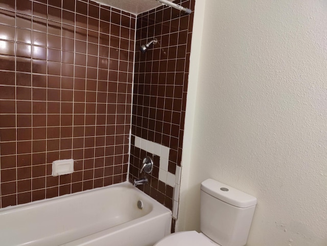 bathroom with tiled shower / bath combo and toilet