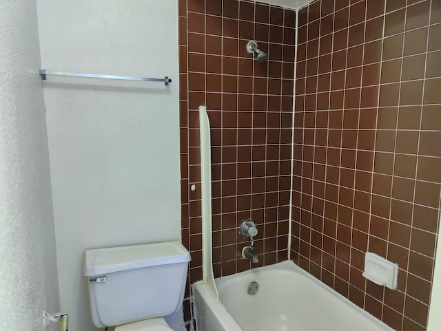 bathroom featuring tiled shower / bath combo and toilet