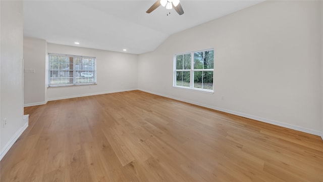 spare room with ceiling fan, vaulted ceiling, and light wood-type flooring