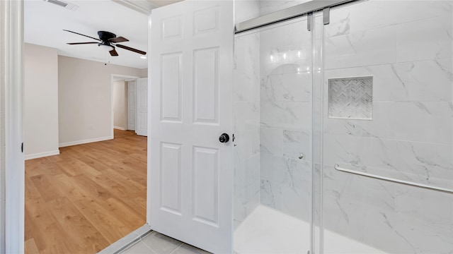 bathroom featuring ceiling fan, a shower with door, and hardwood / wood-style floors