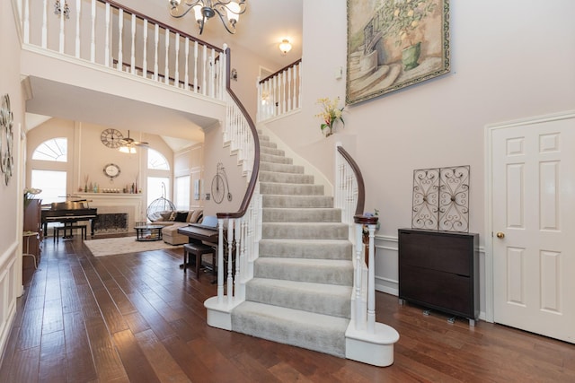 foyer featuring ceiling fan, a towering ceiling, and dark hardwood / wood-style flooring