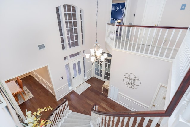 entryway with hardwood / wood-style flooring, a high ceiling, and a notable chandelier