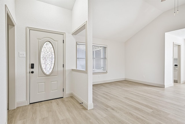 foyer with vaulted ceiling and light wood-type flooring