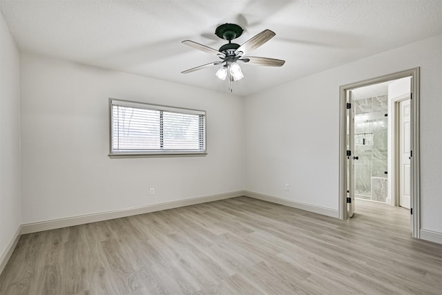 spare room with ceiling fan, light hardwood / wood-style floors, and a textured ceiling