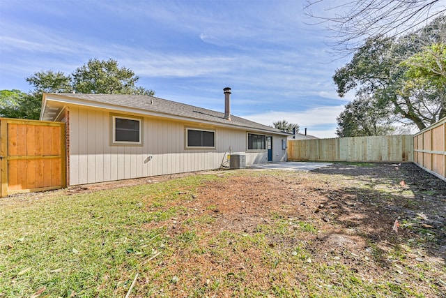 rear view of property featuring central AC, a yard, and a patio area