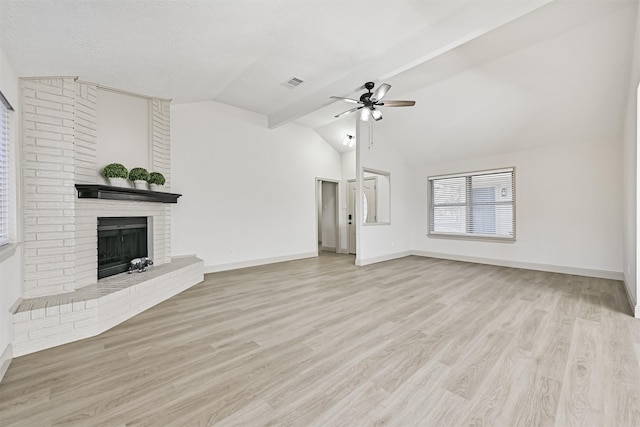 unfurnished living room with vaulted ceiling, ceiling fan, a brick fireplace, a textured ceiling, and light hardwood / wood-style flooring