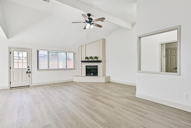 unfurnished living room featuring ceiling fan, a fireplace, light hardwood / wood-style floors, and vaulted ceiling with beams