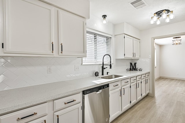 kitchen with dishwasher, sink, backsplash, white cabinets, and light hardwood / wood-style floors