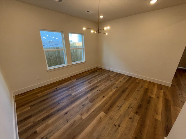 unfurnished dining area featuring dark wood-type flooring and a chandelier