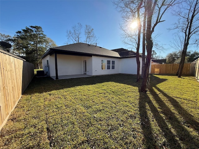 rear view of house featuring a yard, central AC, and a patio