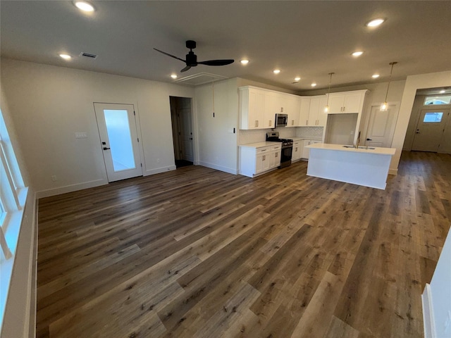 kitchen featuring sink, dark wood-type flooring, white cabinetry, stainless steel appliances, and an island with sink