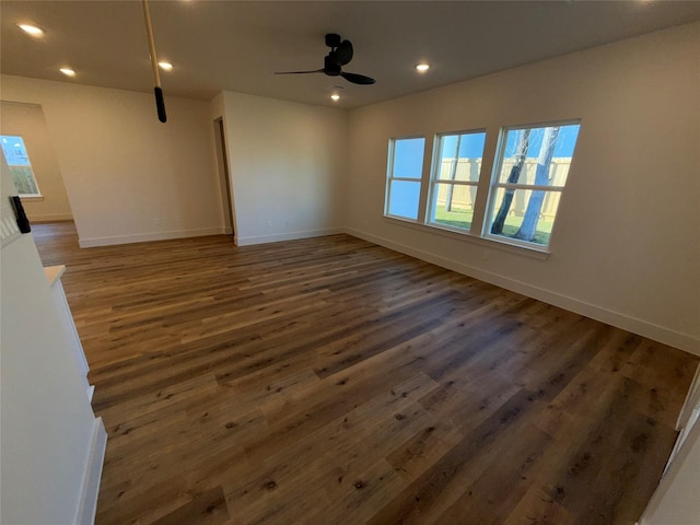 unfurnished room with dark hardwood / wood-style flooring and ceiling fan