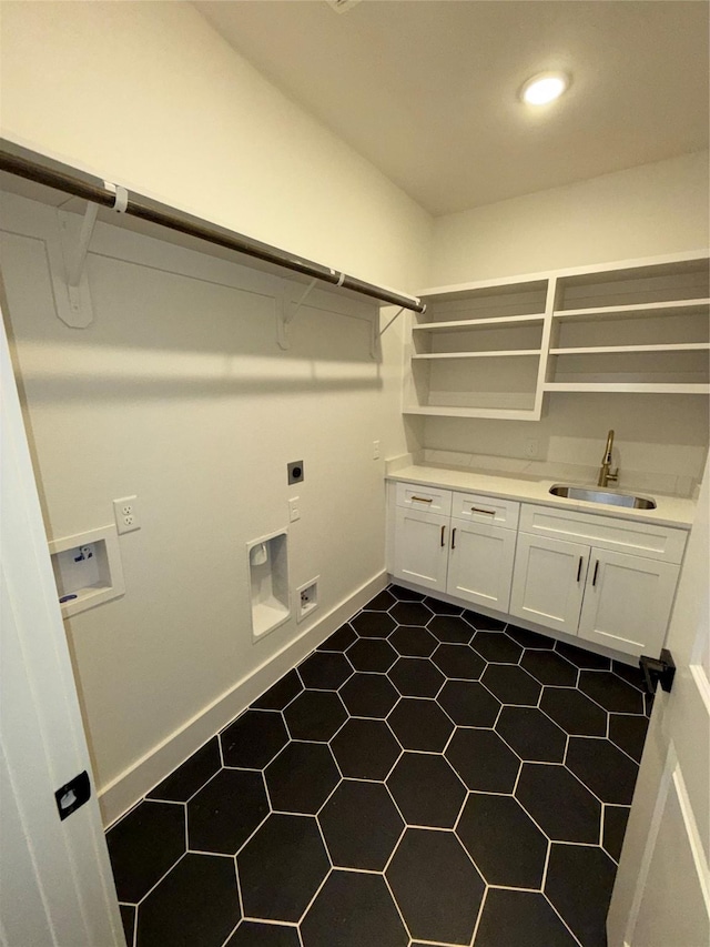 laundry room featuring electric dryer hookup, sink, washer hookup, and cabinets