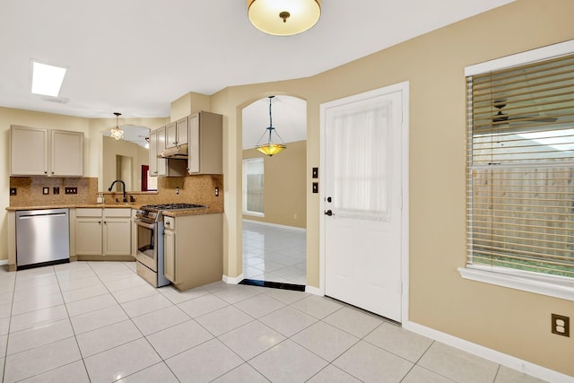 kitchen featuring stainless steel appliances, hanging light fixtures, light tile patterned floors, and backsplash