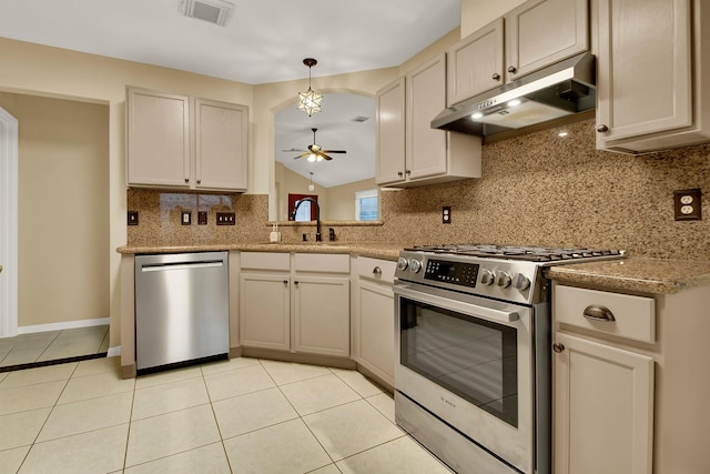 kitchen with light tile patterned flooring, appliances with stainless steel finishes, pendant lighting, and decorative backsplash