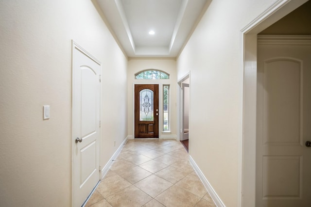 tiled entryway featuring a tray ceiling